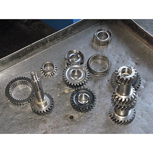 Disassembled silver metal gears and shafts from a Ford Toploader transmission.
