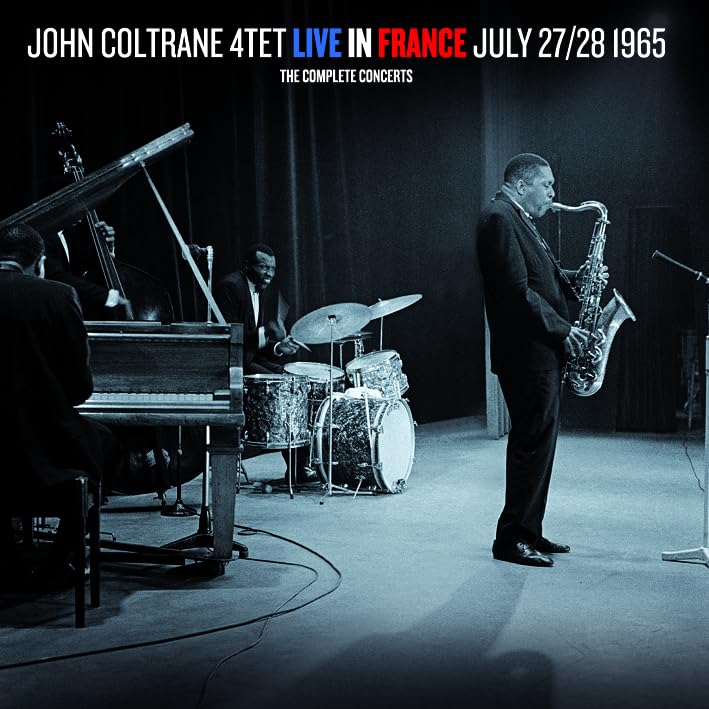 John Coltrane playing saxophone on stage with his quartet in a blue-tinted concert photo.