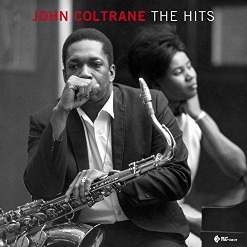 Black and white photo of John Coltrane holding a saxophone with a woman behind.
