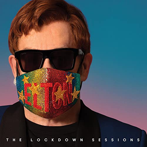 Elton John wearing a colorful, star-covered face mask and sunglasses.