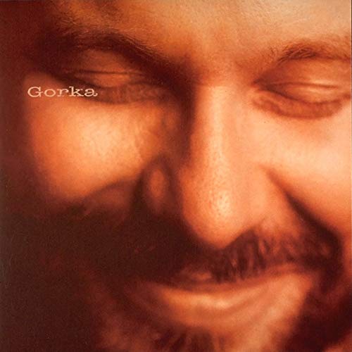 Close-up portrait of John Gorka with eyes closed, in warm sepia tones.