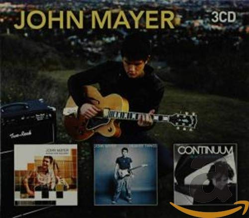 John Mayer holding a guitar, with album covers in the foreground.