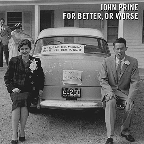 Black and white photo of a couple with a car decorated for a wedding.