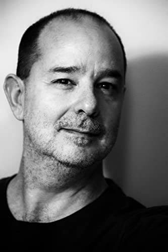 Black and white portrait of a man with short hair and stubble.