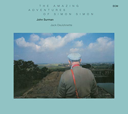 CD cover: man with camera overlooking a green, expansive landscape.