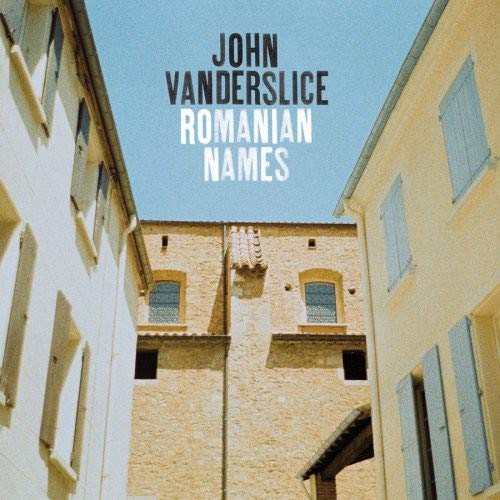 Album cover showing a narrow street between stone buildings under a clear blue sky.
