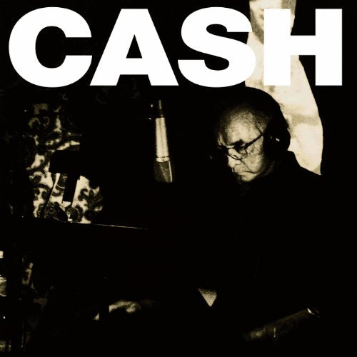 Black and white portrait of Johnny Cash recording in a studio.
