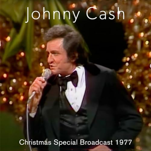 Johnny Cash in tuxedo singing into a microphone with Christmas lights.