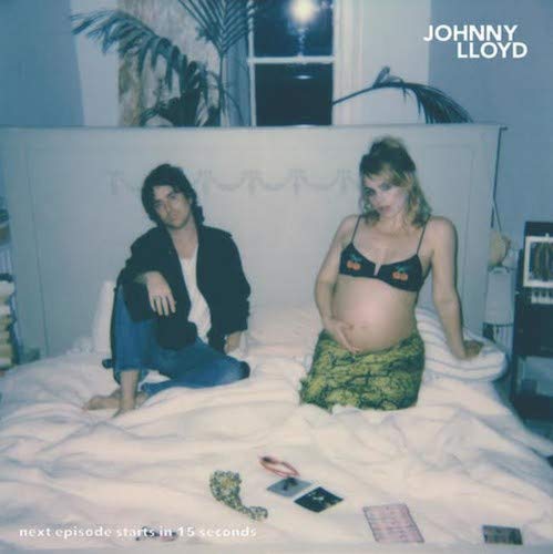 Album cover with pregnant woman and man sitting on a bed together.