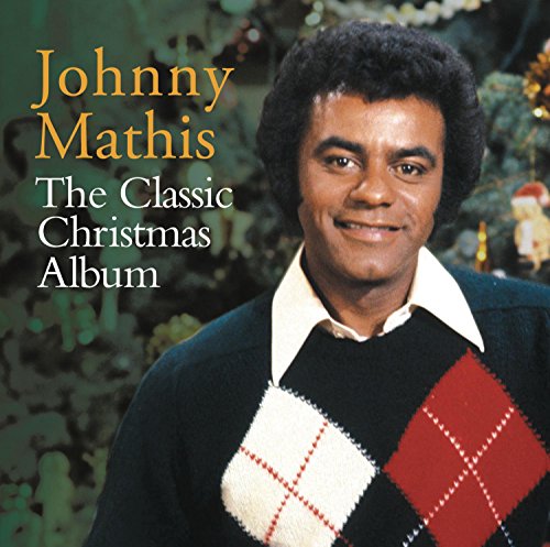 Johnny Mathis smiles on a Christmas album cover with festive sweater and tree.