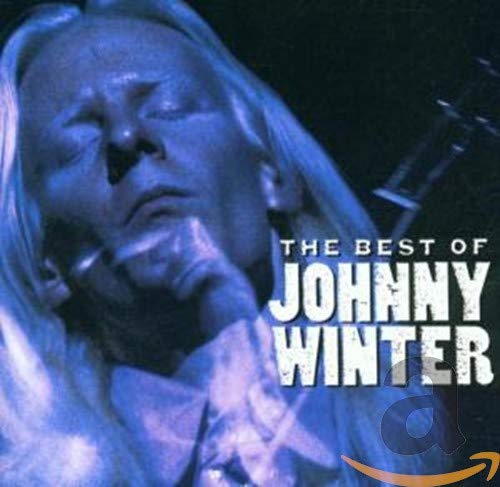 Close-up portrait of Johnny Winter with long white hair in blue lighting.