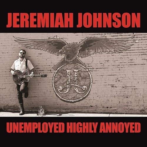 Vinyl album cover with man playing guitar beside a brick wall with eagle emblem.