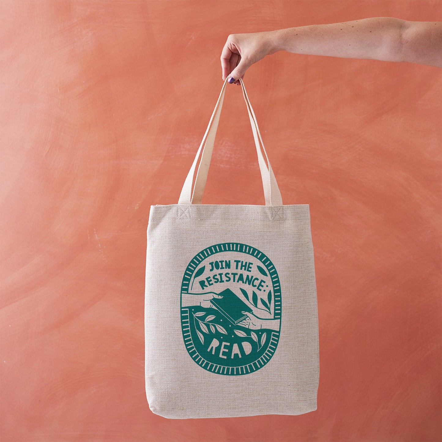 Beige tote bag with green circular design reading “Join the Resistance: Read.”