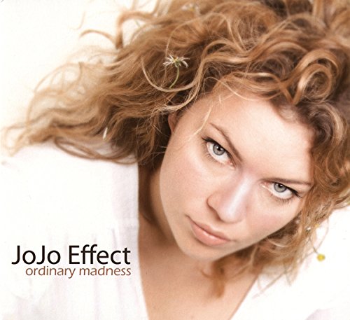 Close-up of a woman with curly hair holding a daisy, album cover.