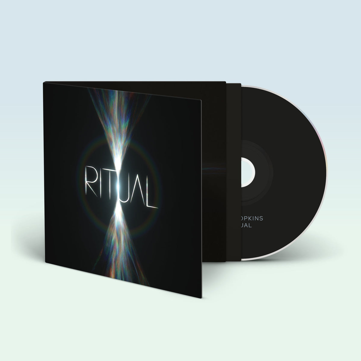 Jon Hopkins' "Ritual" CD case and disc, with abstract light design.