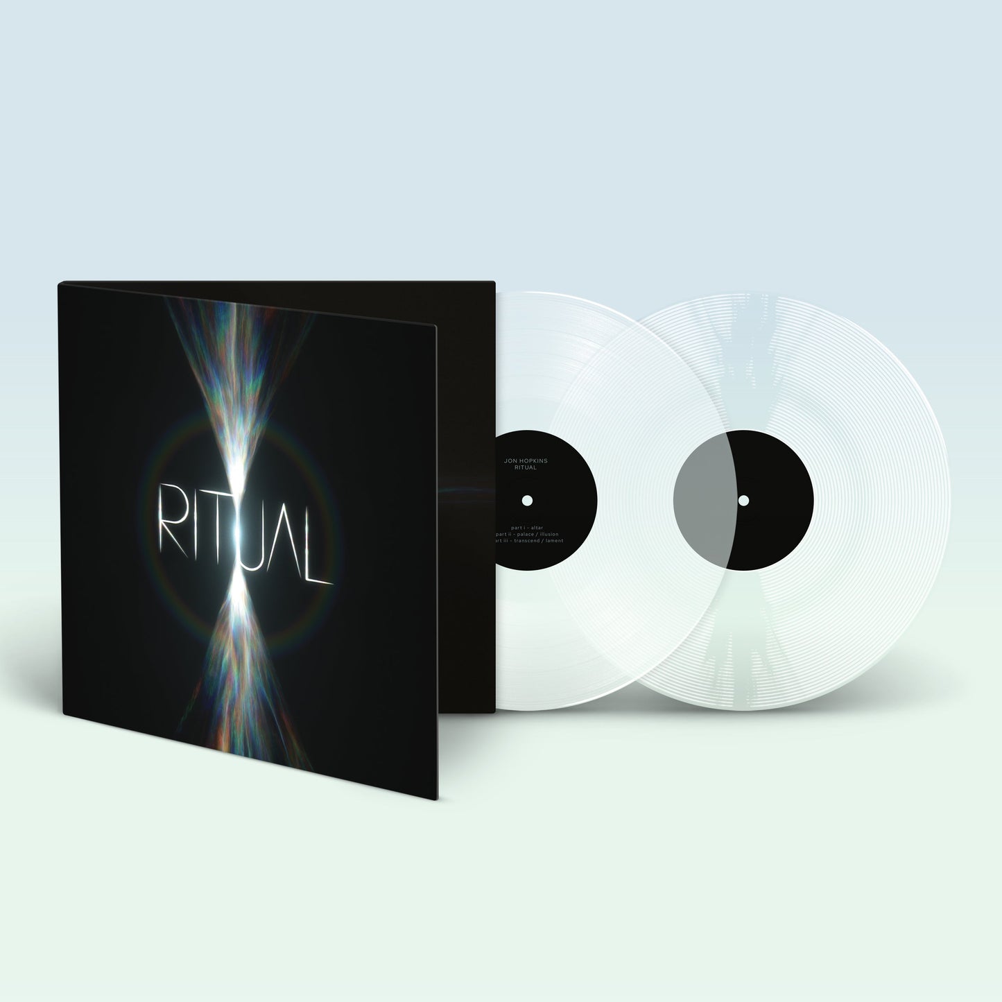 Open gatefold vinyl record sleeve with two clear discs on a light background.