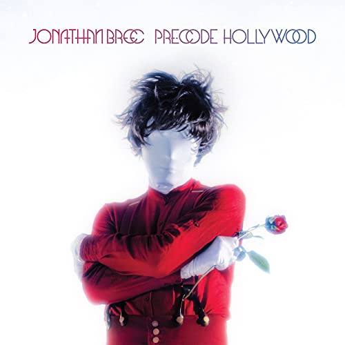 Album cover: man with obscured face in red suit holding a rose.