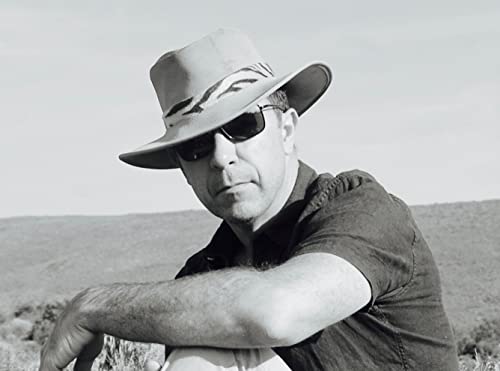 Black and white portrait of a man wearing a hat and sunglasses.