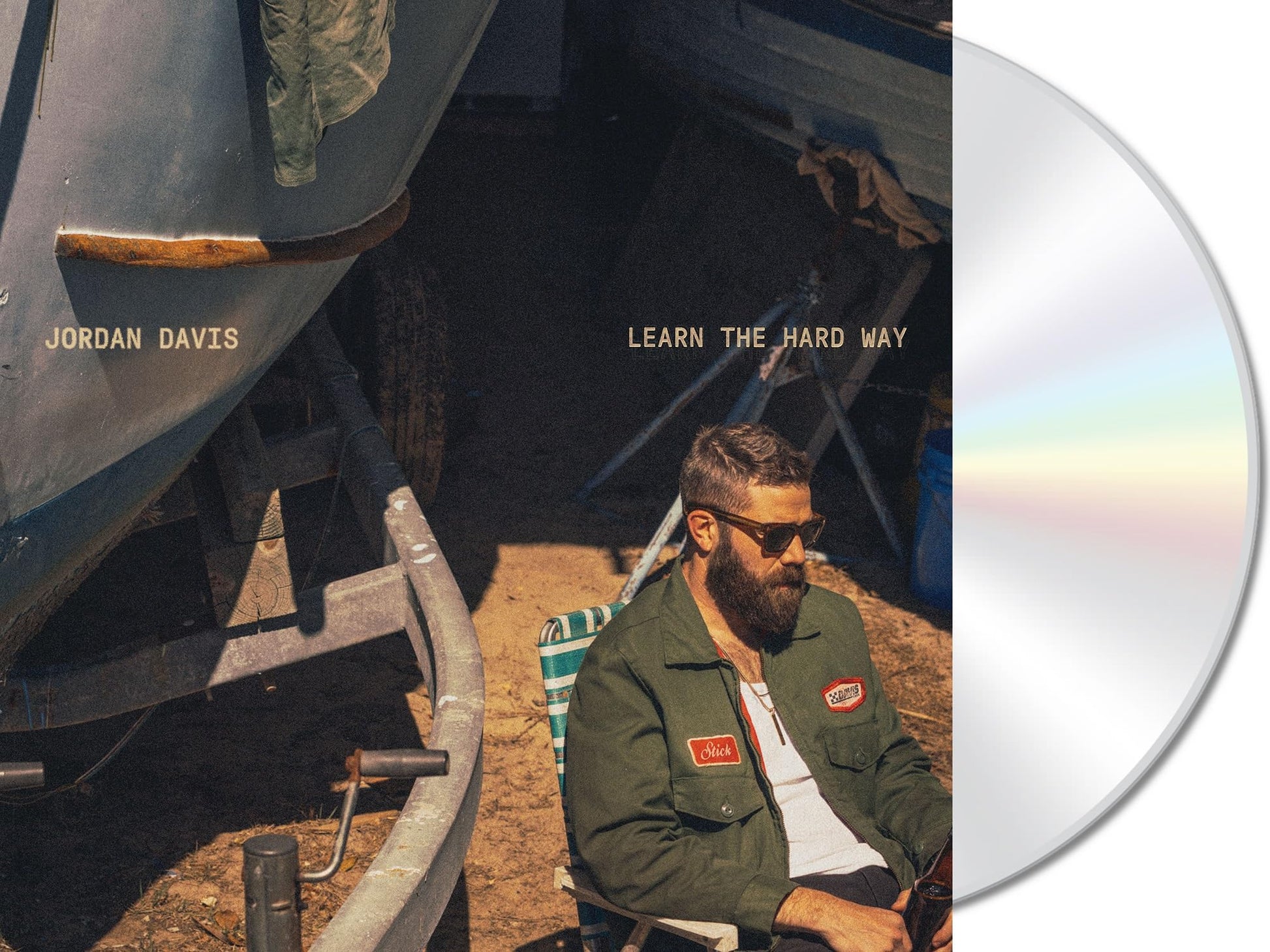 CD cover featuring Jordan Davis seated near a weathered boat.