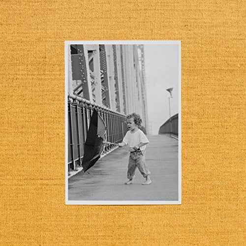 Black and white album cover featuring a child running with an umbrella.