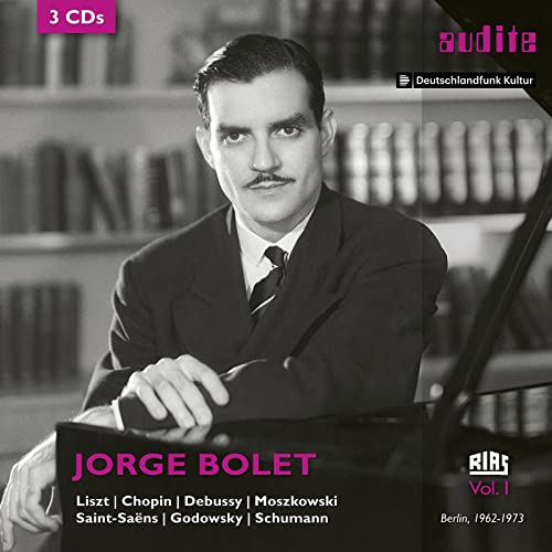 Black and white portrait of pianist Jorge Bolet sitting at a piano in a library.