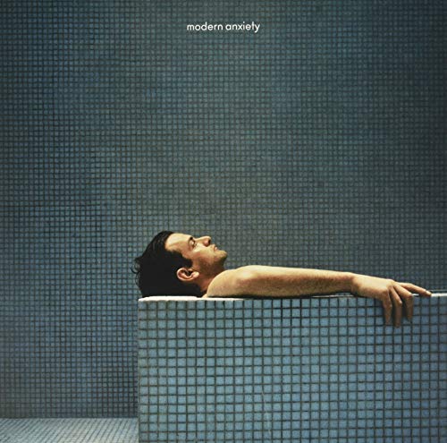 Album cover: man lying in blue-tiled water, looking upwards.