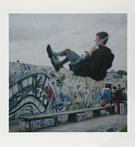 Man mid-air in front of a graffiti-covered wall, vinyl record cover.