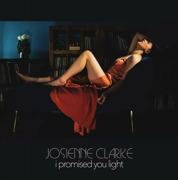 Album cover: woman in orange dress reclines on a dark couch.