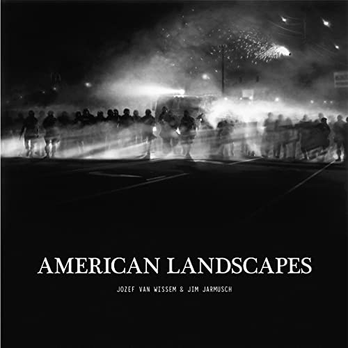 Black and white photo of a crowd at night with fireworks, album title.