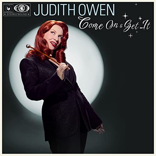 Judith Owen album cover, woman in suit holding a baton.