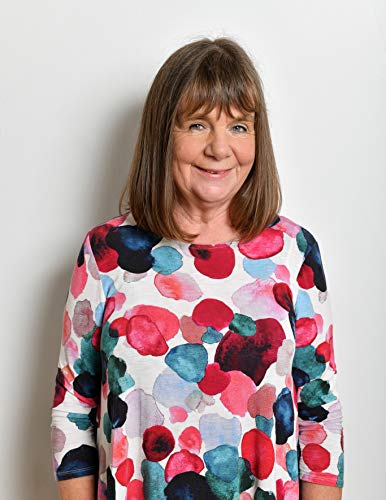 Woman with shoulder-length brown hair wearing a floral print top.