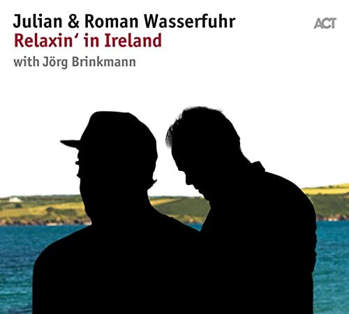 Silhouettes of two men facing away from the viewer, coastal background.