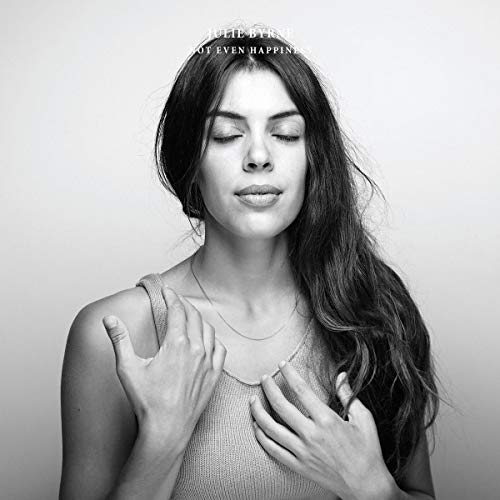 Black and white photo of woman with hands on chest and eyes closed.