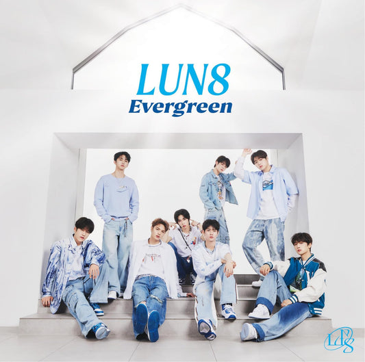 Eight young men in denim pose under an abstract white arch.