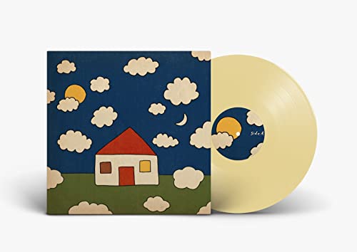 Cream-colored vinyl record next to album cover featuring a house under a night sky.