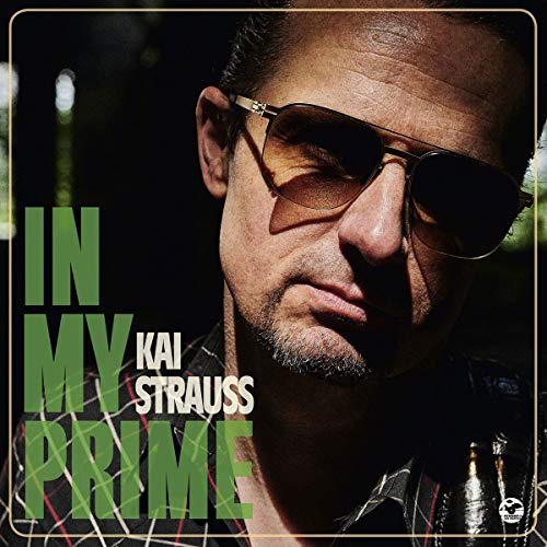 Close-up portrait of Kai Strauss wearing sunglasses, album cover art.