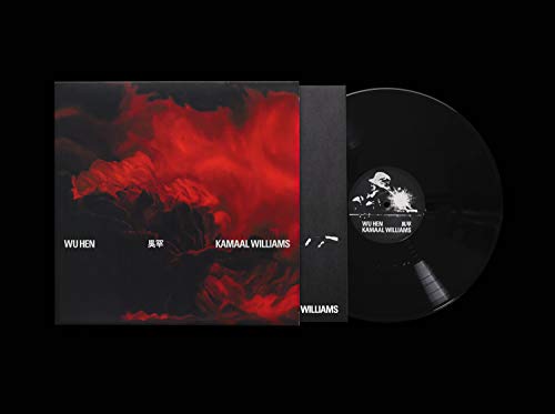 Vinyl record with black sleeve and red abstract cover art, partially visible.