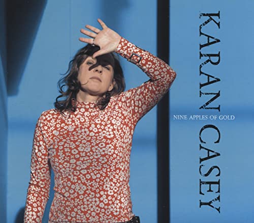 CD cover: Karan Casey raising hand, floral patterned shirt, blue background.