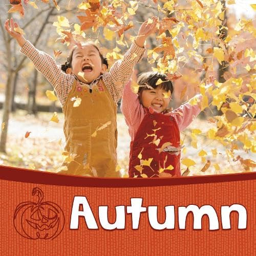 Two children joyfully play in falling yellow and orange autumn leaves.