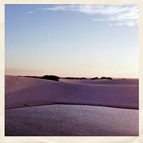 Vinyl record cover depicting a sandy landscape under a pale sky.
