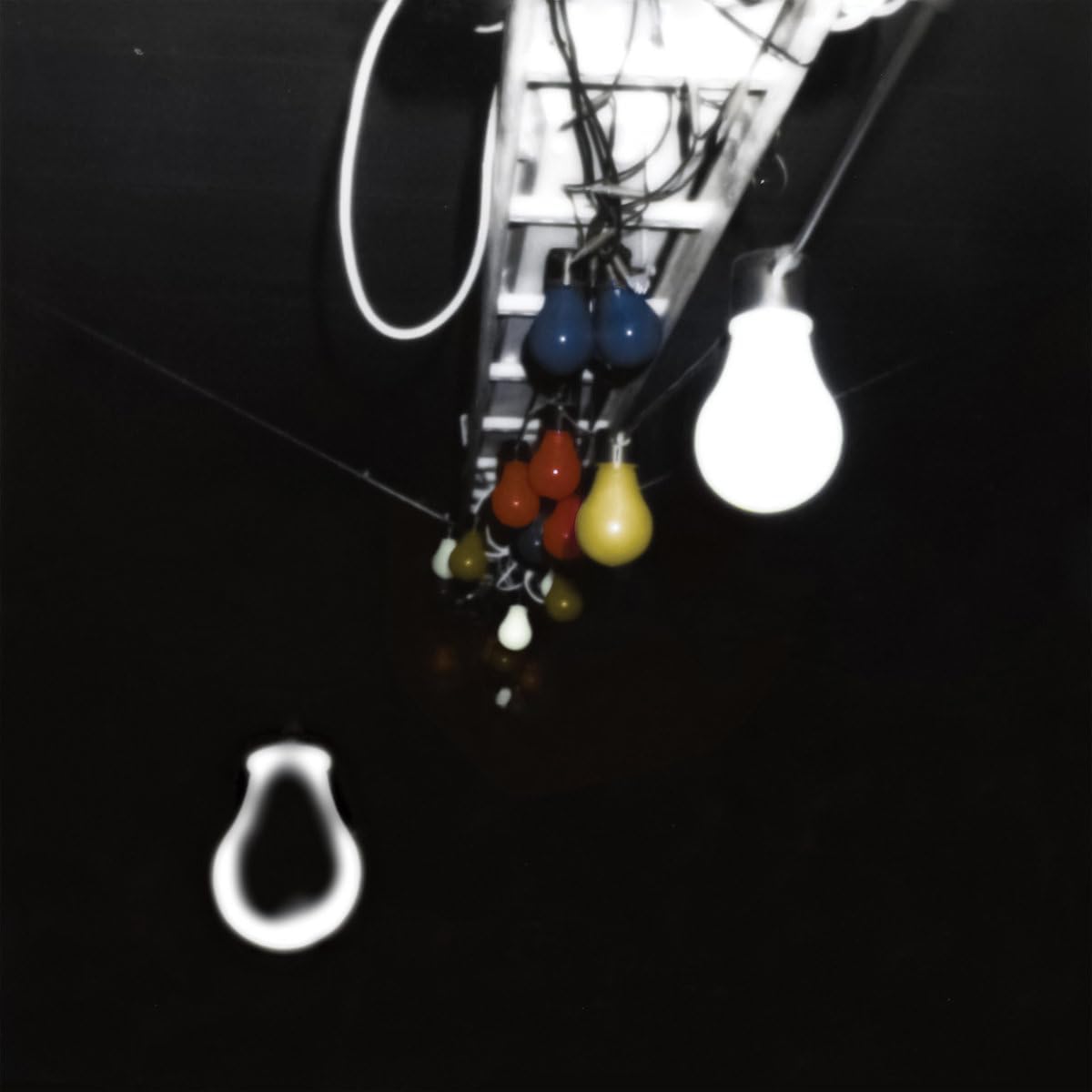 Black and white photo of hanging lightbulbs and electrical wiring.