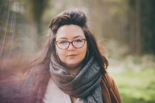 Woman with glasses and scarf, author of “My Husband’s Murder.”