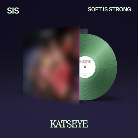 A green vinyl record emerging from a blurred album cover against a dark background.
