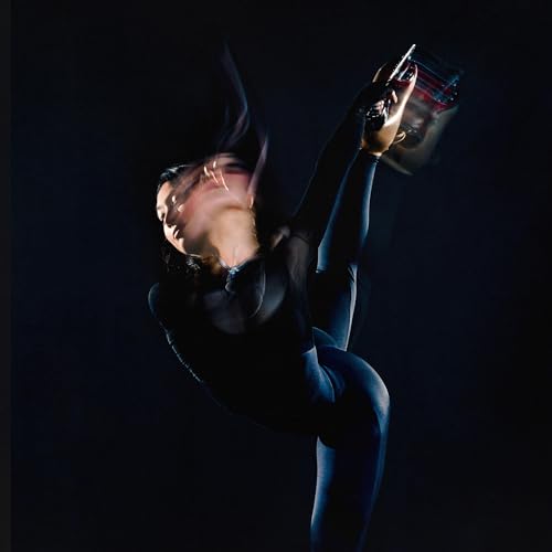 Dynamic motion blur of a dancer in a dark studio setting.