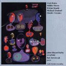 The image is a blurry album cover with abstract shapes and text on a grey background.