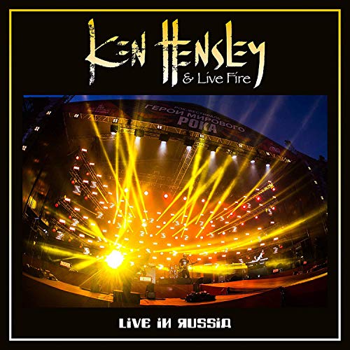 "Album cover with stage lights and text 'Ken Hensley & Live Fire - Live in Russia'."