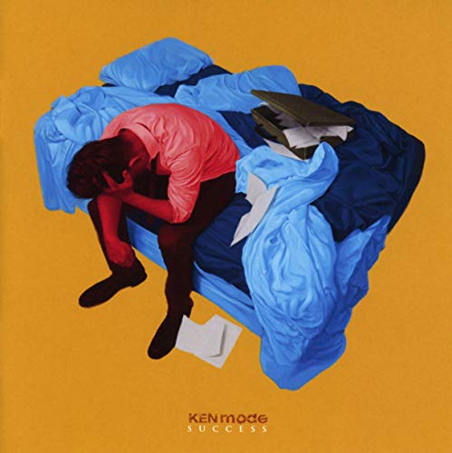 Album cover: person slumped amidst blue fabric and scattered papers.