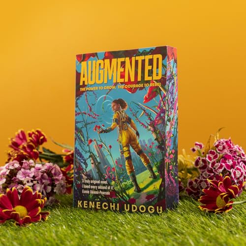 The book Augmented by Kenechi Udogu stands on grass surrounded by colorful flowers.
