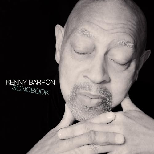 Black and white portrait of Kenny Barron with eyes closed and hands clasped.
