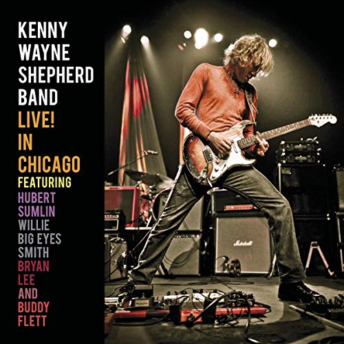 Kenny Wayne Shepherd playing electric guitar on stage with text on the left side.